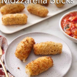 Pinterest graphic of a plate with three air fryer mozzarella sticks with a platter in the background with more.