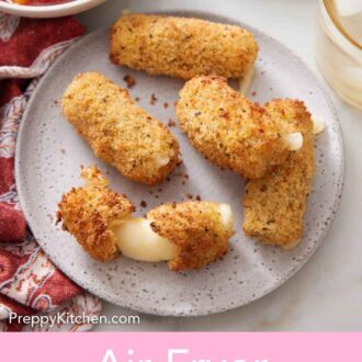 Pinterest graphic of a plate of air fryer mozzarella sticks with one torn in half, showing the cheese stretched.A bowl of marinara sauce off to the side.
