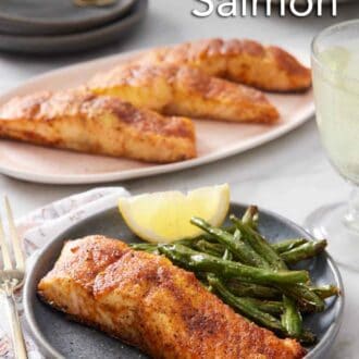 Pinterest graphic of a plate with air fryer salmon along with green beans and a lemon wedge. A platter of more salmon in the background and plate of green beans.