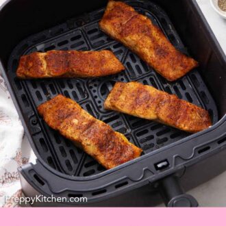 Pinterest graphic of an overhead view of salmon in an air fryer basket.