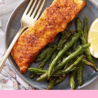 Pinterest graphic of an overhead view of a plate with a piece of air fryer salmon with green beans and a lemon wedge.
