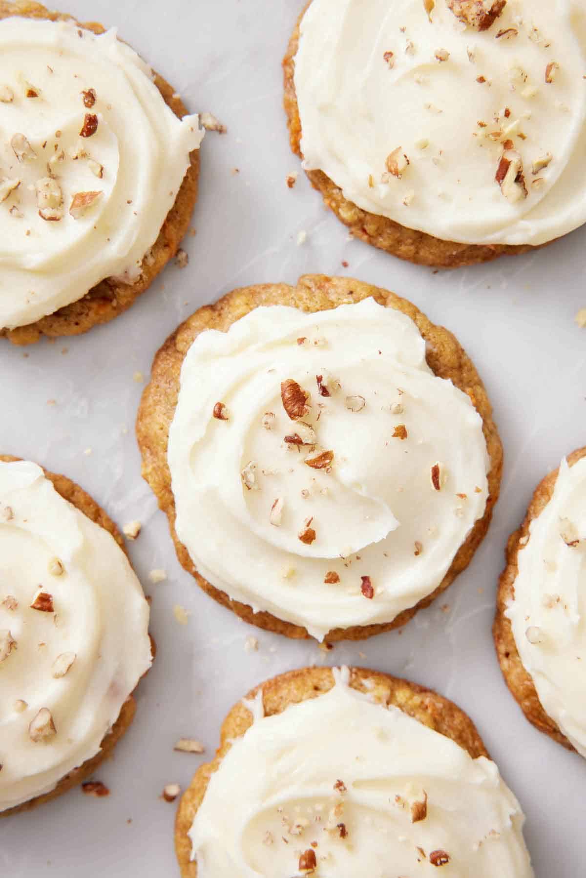 Overhead view of carrot cake cookies topped with chopped pecans.