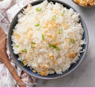 Pinterest graphic of an overhead view of a bowl of coconut rice topped with green onions and toasted coconut. A bowl of toasted coconuts on the side.