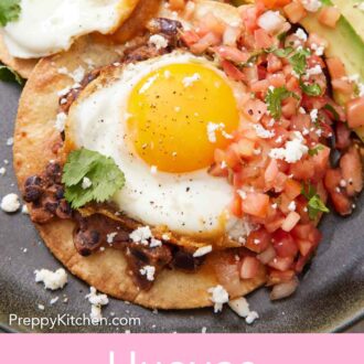 Pinterest graphic of close view of huevos rancheros on a plate topped with pico de gallo, crumbled cheese, cilantro, and avocados.