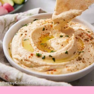 Pintrest graphic of a piece of pita bread dipped into a bowl of hummus.