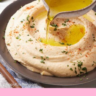 Pintrest graphic of oil poured over a bowl of hummus with paprika and parsley garnish.