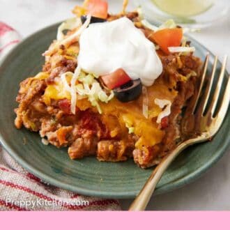 Pinterest graphic of a plate with a serving og taco casserole topped with sour cream.