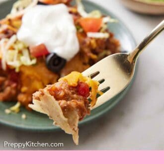 Pinterest graphic of a forkful of taco casserole lifted from a plate.