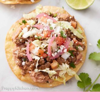 Pinterest graphic of tostadas with toppings on a marble surface with two lime wedges and cilantro on the side.