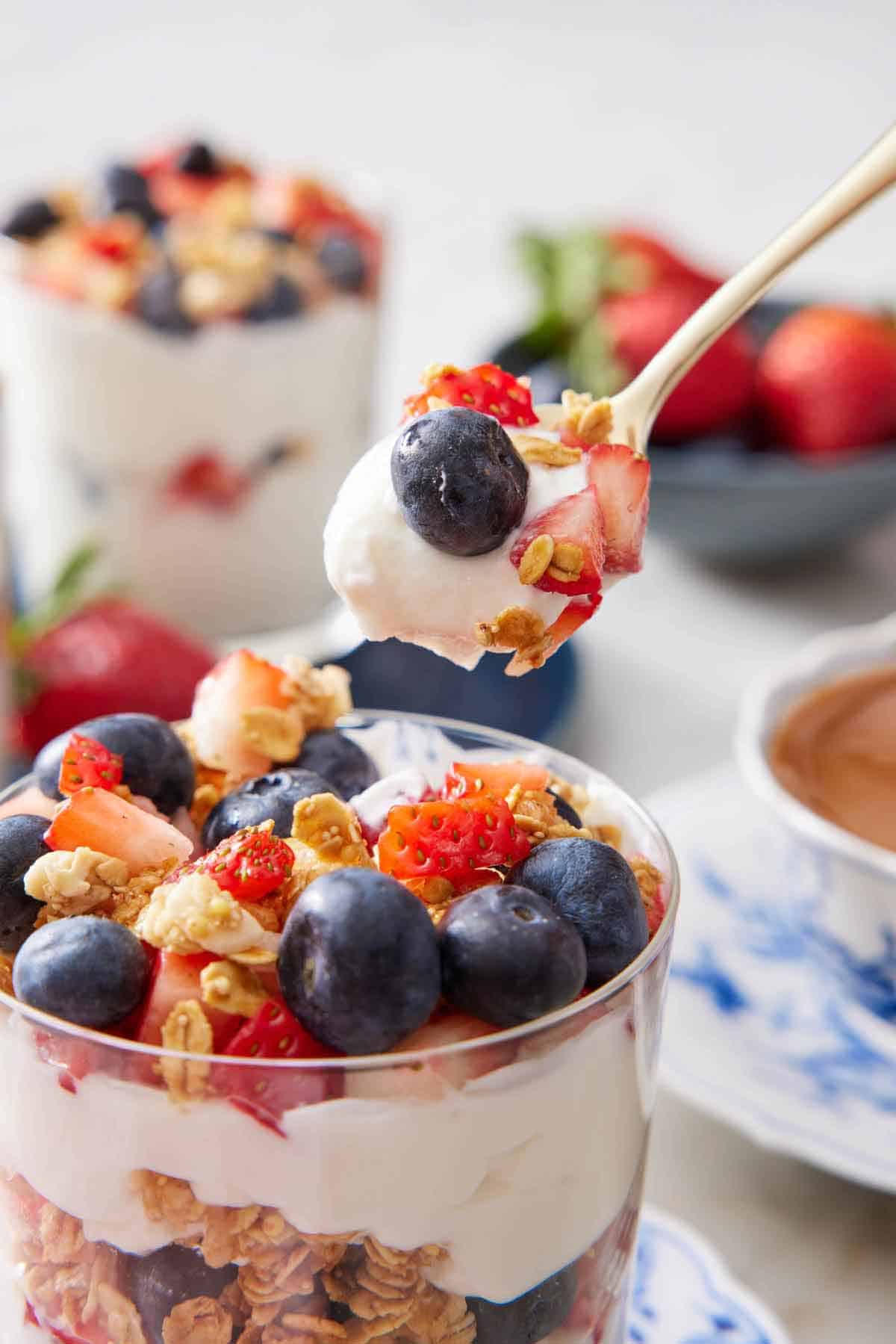 A spoonful of yogurt parfait lifted from the glass.