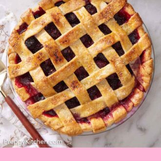 Pinterest graphic of an overhead view of a blackberry pie. Whipped cream on the side along with some forks on a plate.