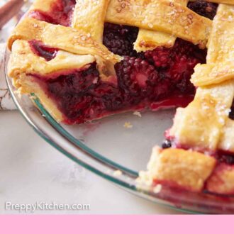 Pinterest graphic of a close up view of a blackberry pie with a slice cut out, showing the berry-filled interior.