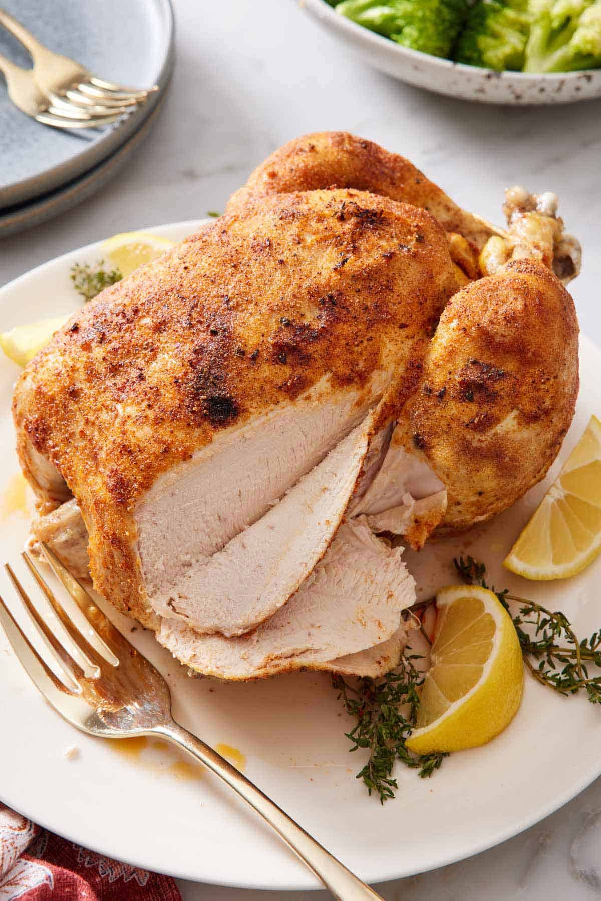 A plate with an instant pot whole chicken with the breast sliced.