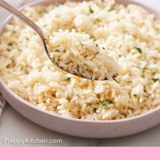 Pinterest graphic of a spoonful of rice pilaf lifted from a plate.