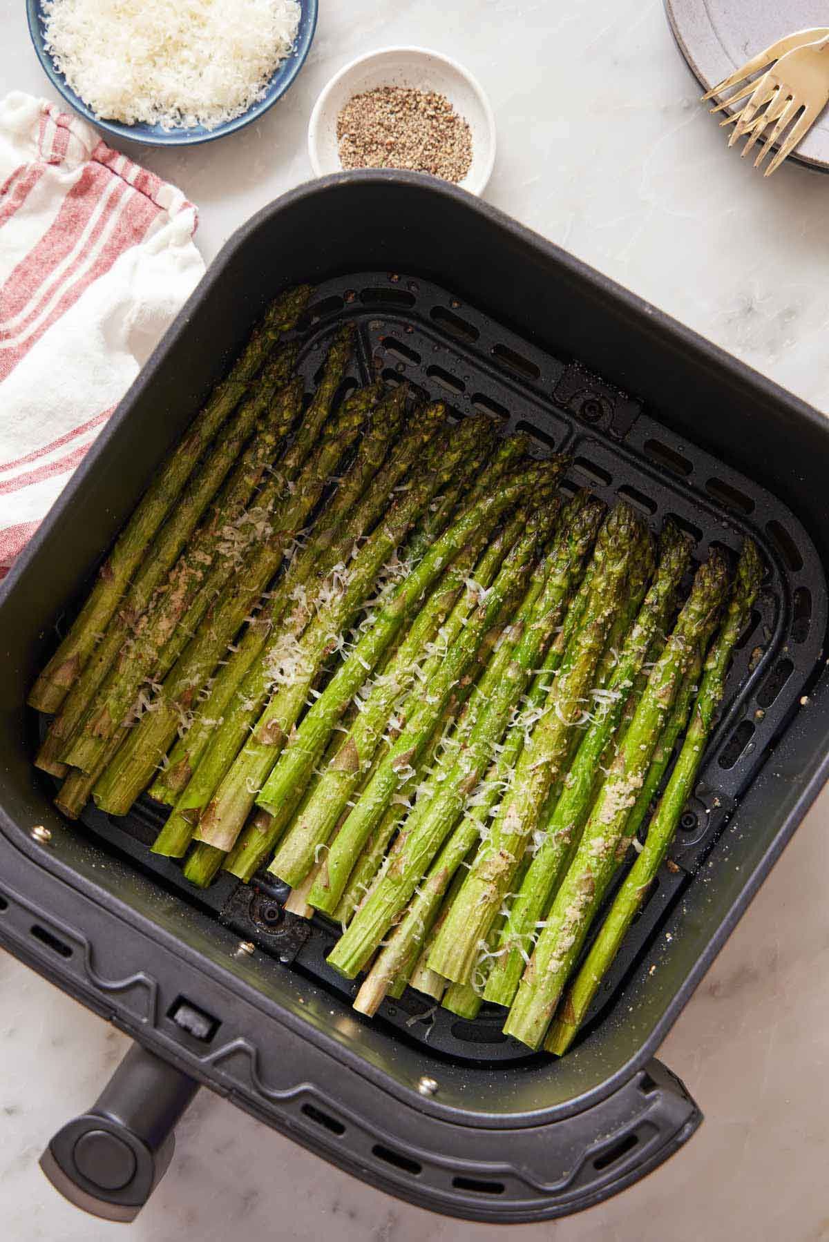 Overhead view of air fryer asparagus in an air fryer basket.