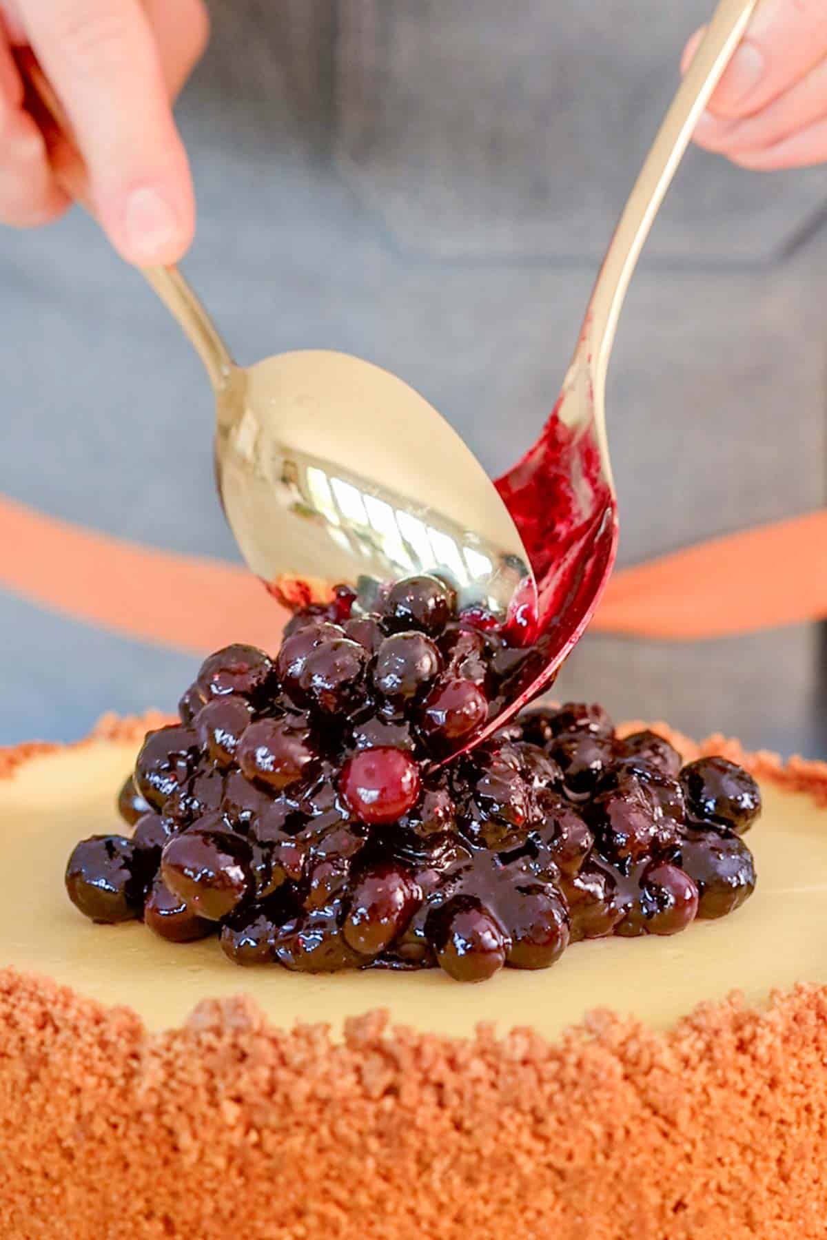 Blueberry sauce spooned on top of a blueberry cheesecake.