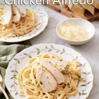 Pinterest graphic of a plate with a serving of Instant Pot chicken alfredo with a second plate in the back along with a bowl of cheese and sliced bread.