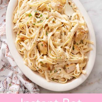 Pinterest graphic of a serving platter of Instant Pot chicken alfredo with a fork. Sliced bread in the back.