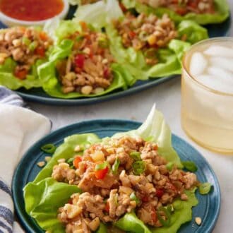 Pinterest graphic of a serving of lettuce wrap on a plate with more in the back on a platter with an iced drink.