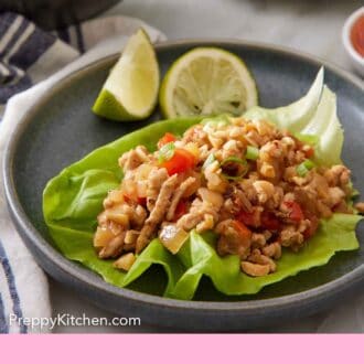 Pinterest graphic of a plate with a serving of lettuce wrap with lime wedges.