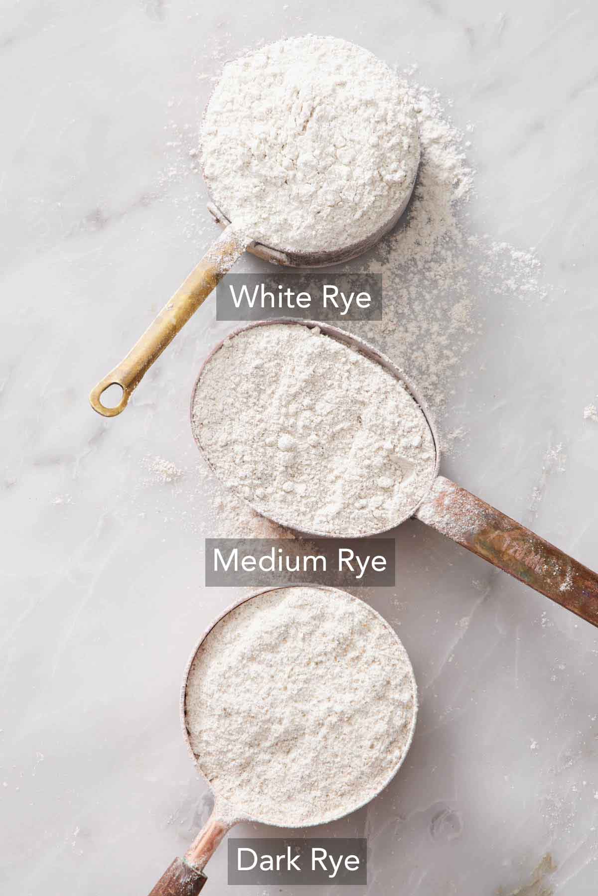 Three scoops of different varieties of rye flour.
