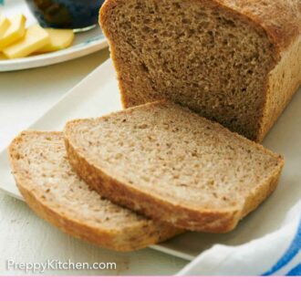 Pinterest graphic of a loaf of rye bread with two slices cut. Jam and butter in the background.