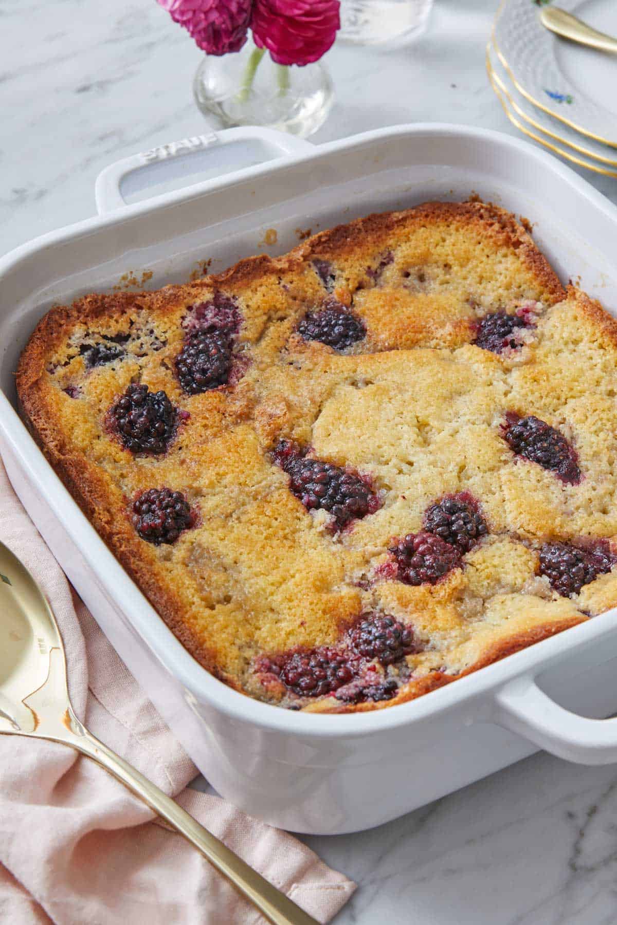 A white baking dish with blackberry cobbler.
