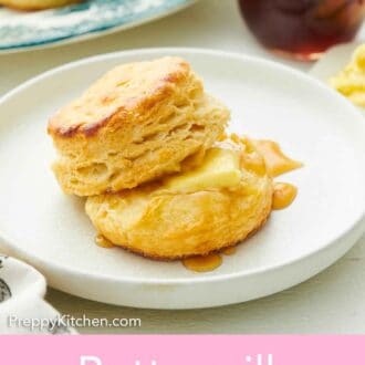 Pinterest graphic of a plate with buttermilk biscuits with some honey and butter. A jar of honey in the background and more biscuits.