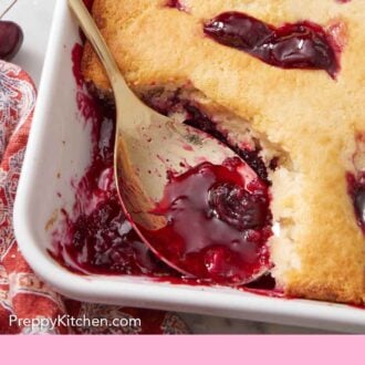 Pinterest graphic of a spoon inside of a baking dish of cherry cobbler.