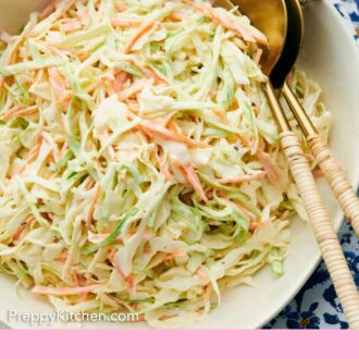 Pinterest graphic of a close up view of coleslaw in a platter with serving spoons.
