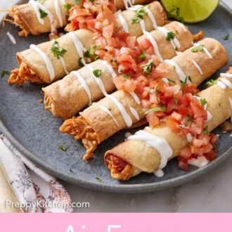 Pinterest graphic of a plate of a lime wedge and air fryer taquitos topped with sour cream and salsa.