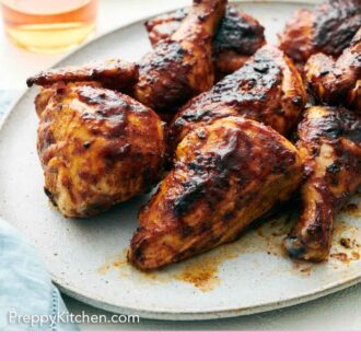 Pinterest graphic of a platter of BBQ chicken with a drink in the background.