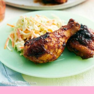 Pinterest graphic of a plate with two pieces of BBQ chicken with coleslaw.