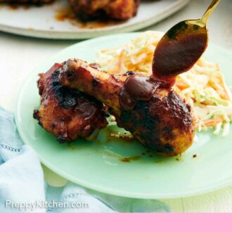 Pinterest graphic of BBQ sauce spooned over a piece of BBQ chicken on a plate with coleslaw.