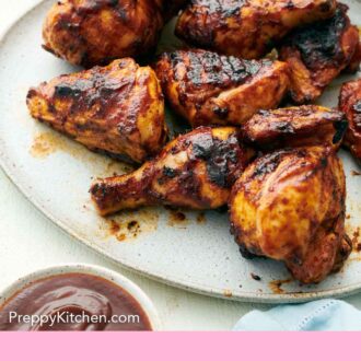 Pinterest graphic of a platter of BBQ chicken with a bowl of sauce in front.