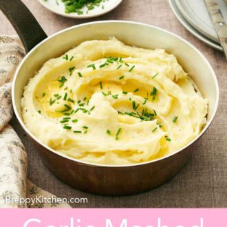 Pinterest graphic of a saucepan with garlic mashed potatoes topped with chives and butter.