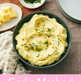 Pinterest graphic of a green bowl of garlic mashed potatoes topped with chives and pepper.