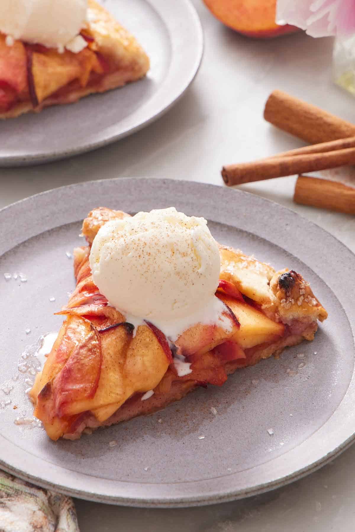 A slice of peach galette with a scoop of ice cream on top.