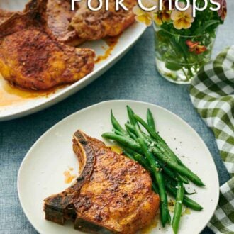 Pinterest graphic of a plate with an air fryer pork chop with green beans. Flowers and platter of more pork chops in the background.