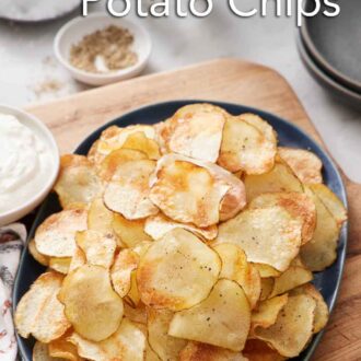 Pinterest graphic of a platter of air fryer potato chips. Some salt, pepper, dip, and plates on the side.