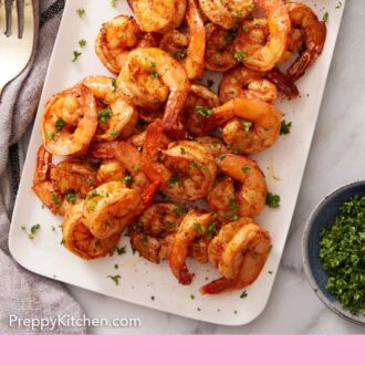 Pinterest graphic of a platter of air fryer shrimp topped with parsley and lemon slices.