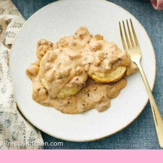 Pinterest graphic of an overhead view of a plate of biscuits and gravy with a fork.