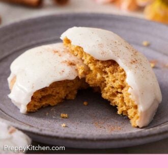 Pinterest graphic of a plate with a pumpkin cookie, torn in half, with one half leaning on top of the other.