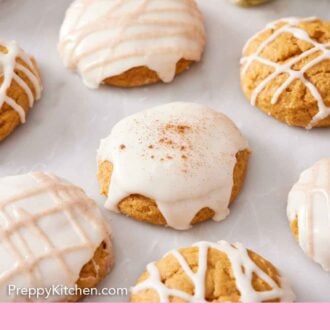 Pinterest graphic of multiple pumpkin cookies iced in different patterns on a marble surface.