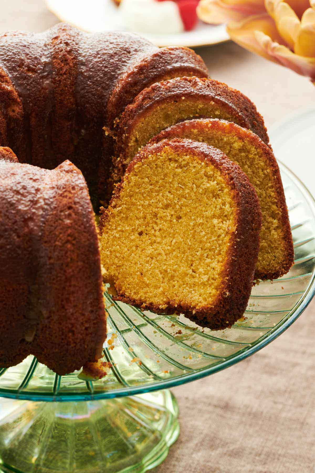 A close up of sliced rum cake on a cake stand, showing the interior.