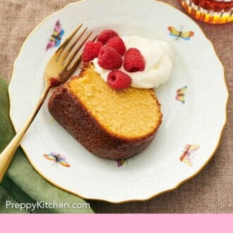 Pinterest graphic of a plate with a slice of rum cake with whipped cream, raspberries, and a fork.