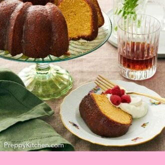 Pinterest graphic of a plate with a slice of rum cake with whipped cream, raspberries, and a fork. A cake stand with the rest of the cake beside it.