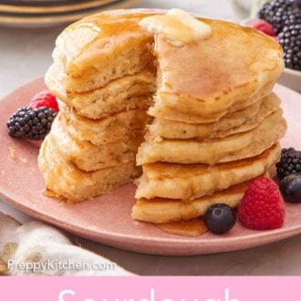 Pinterest graphic of a stack of cut sourdough pancakes on a plate with syrup running down the sides and butter on top.