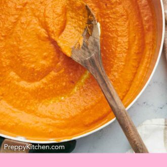 Pinterest graphic of a pot of vodka sauce being turned by a wooden spoon.