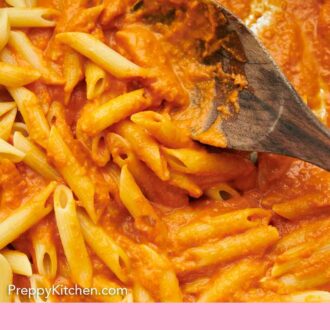 Pinterest graphic of pasta tossed in vodka sauce with a wooden spoon.